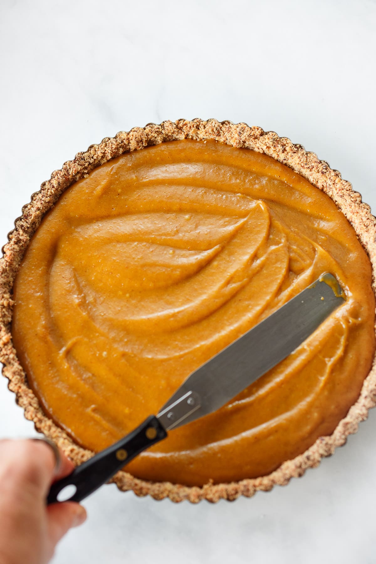 Smoothing the filling into the baked crust.