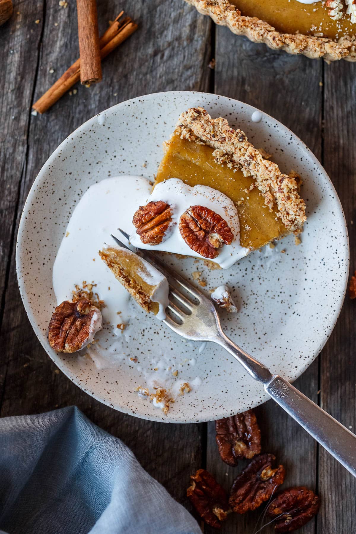 A decadent Vegan Pumpkin Tart with a smooth caramely pumpkin filling in a tender pecan oat crumb crust.  Richly spiced, easy to make, and freezes beautifully.  Perfect for the holidays!