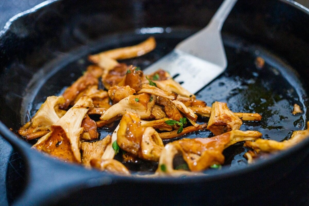 chanterelle mushrooms sauteing in a skillet.