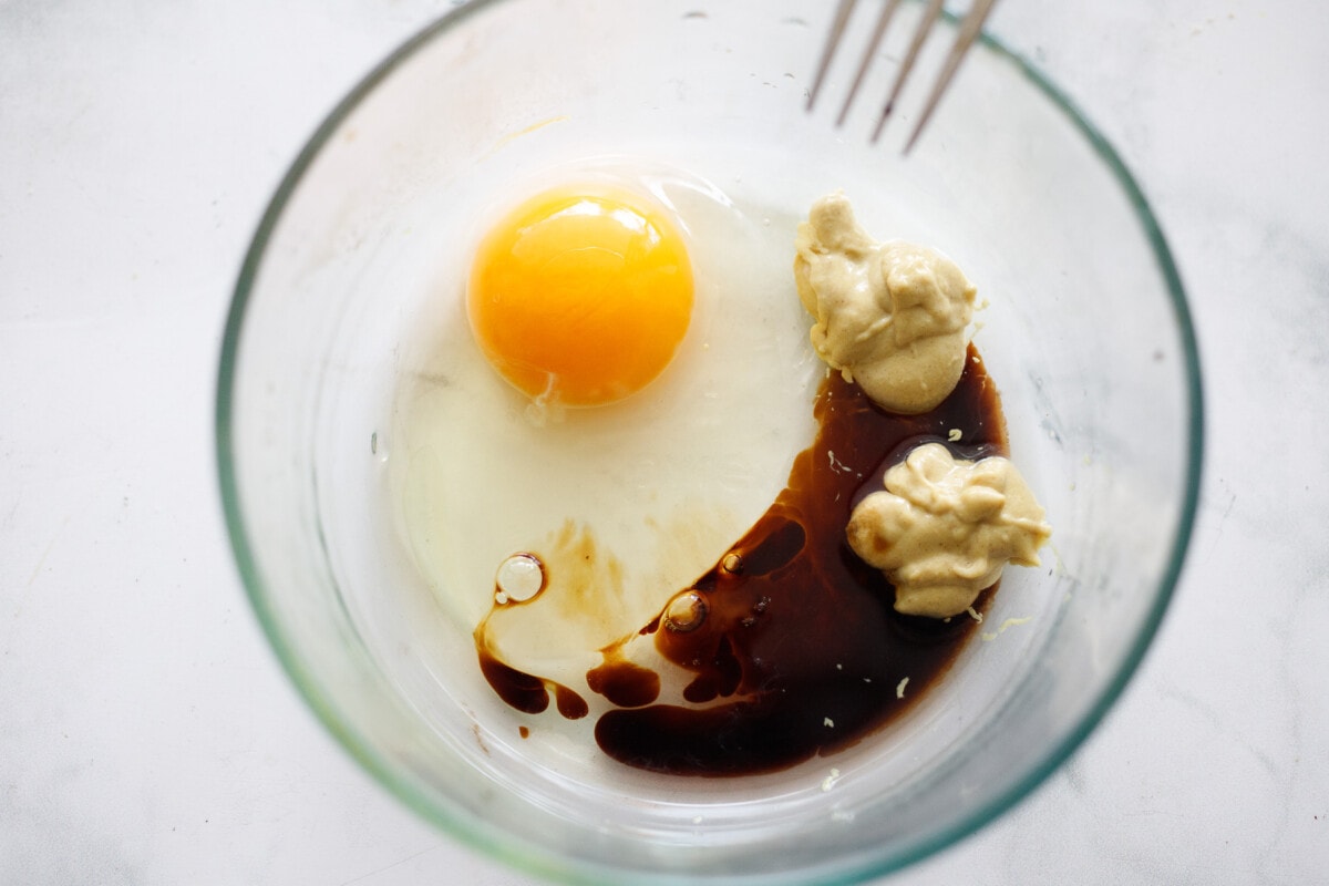 Egg batter ingredients in a bowl- egg, soy sauce and mustard.