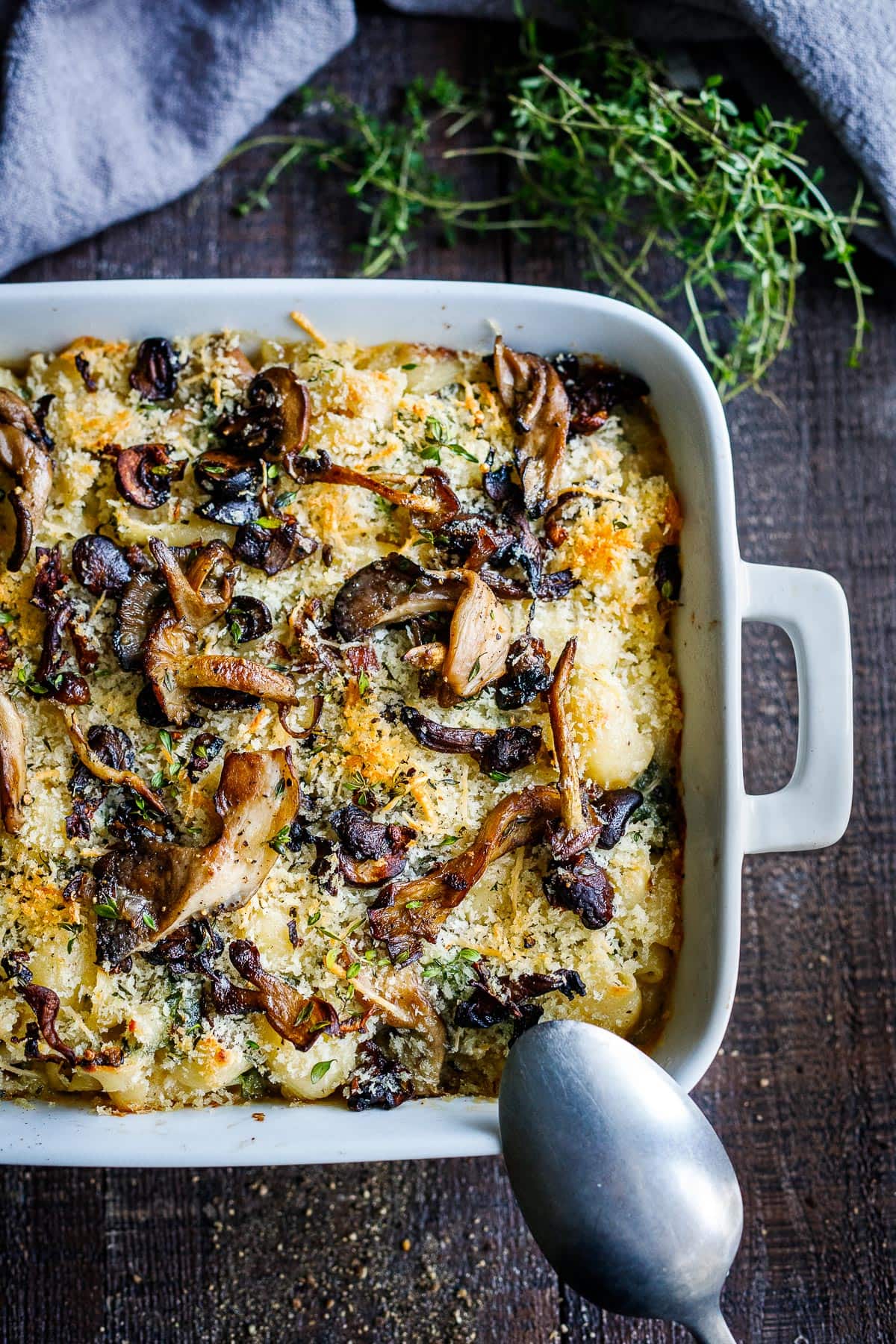 Truffle Mac and Cheese in a white baking dish topped with sautéed wild mushrooms.