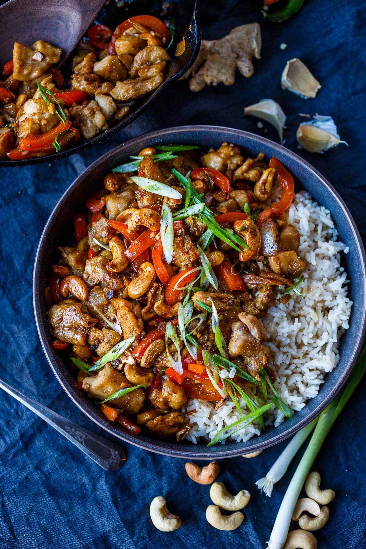 Cashew Chicken in a bowl over rice with scallions. 