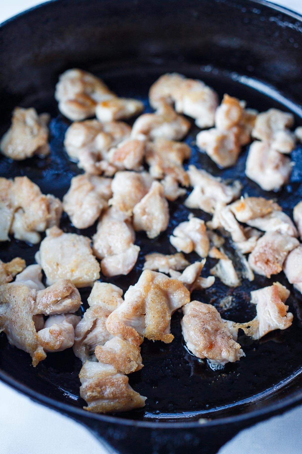 Chicken searing on a pan.