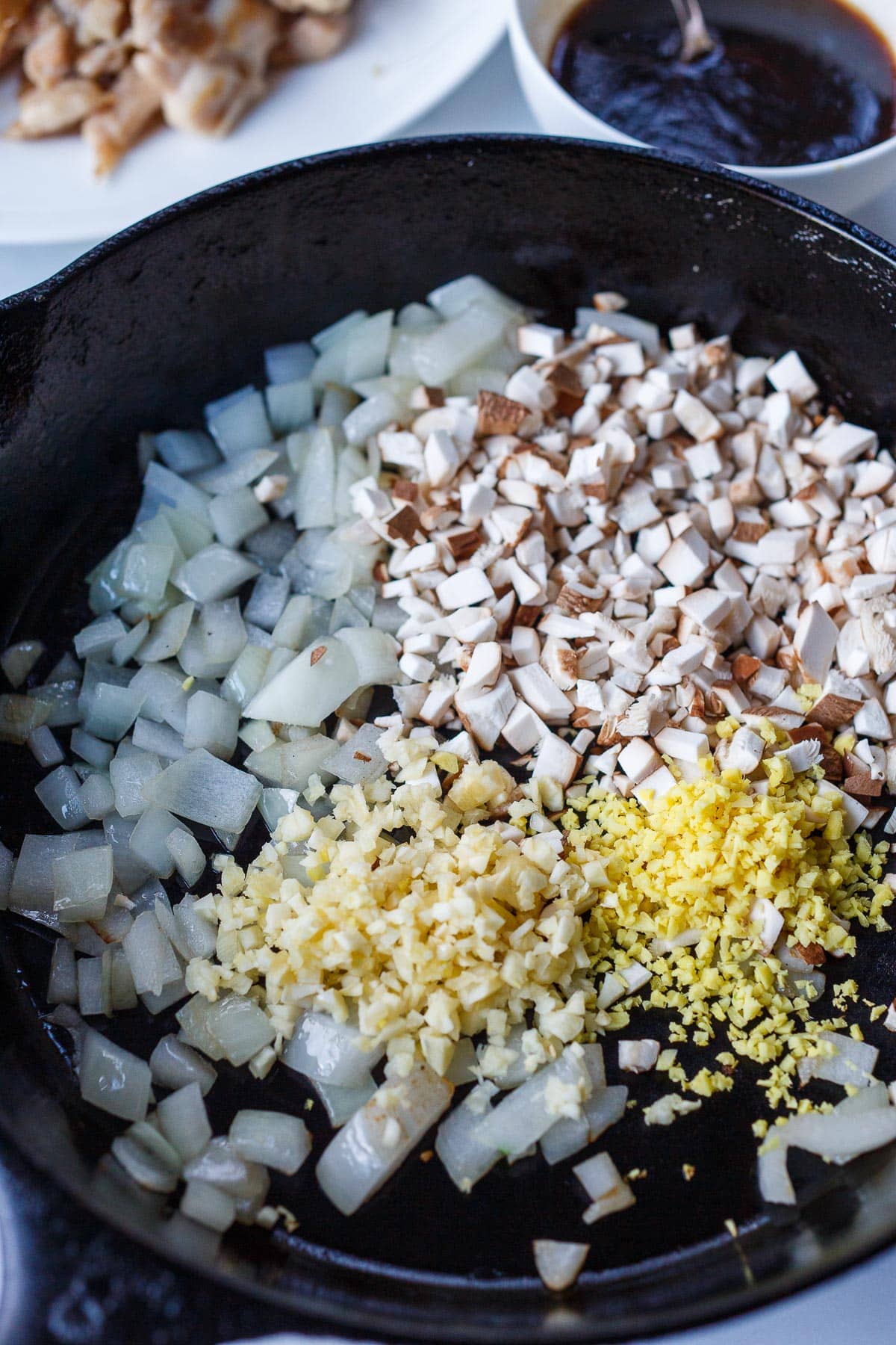 Onions, shiitakes, ginger, garlic sautéing in a pan.