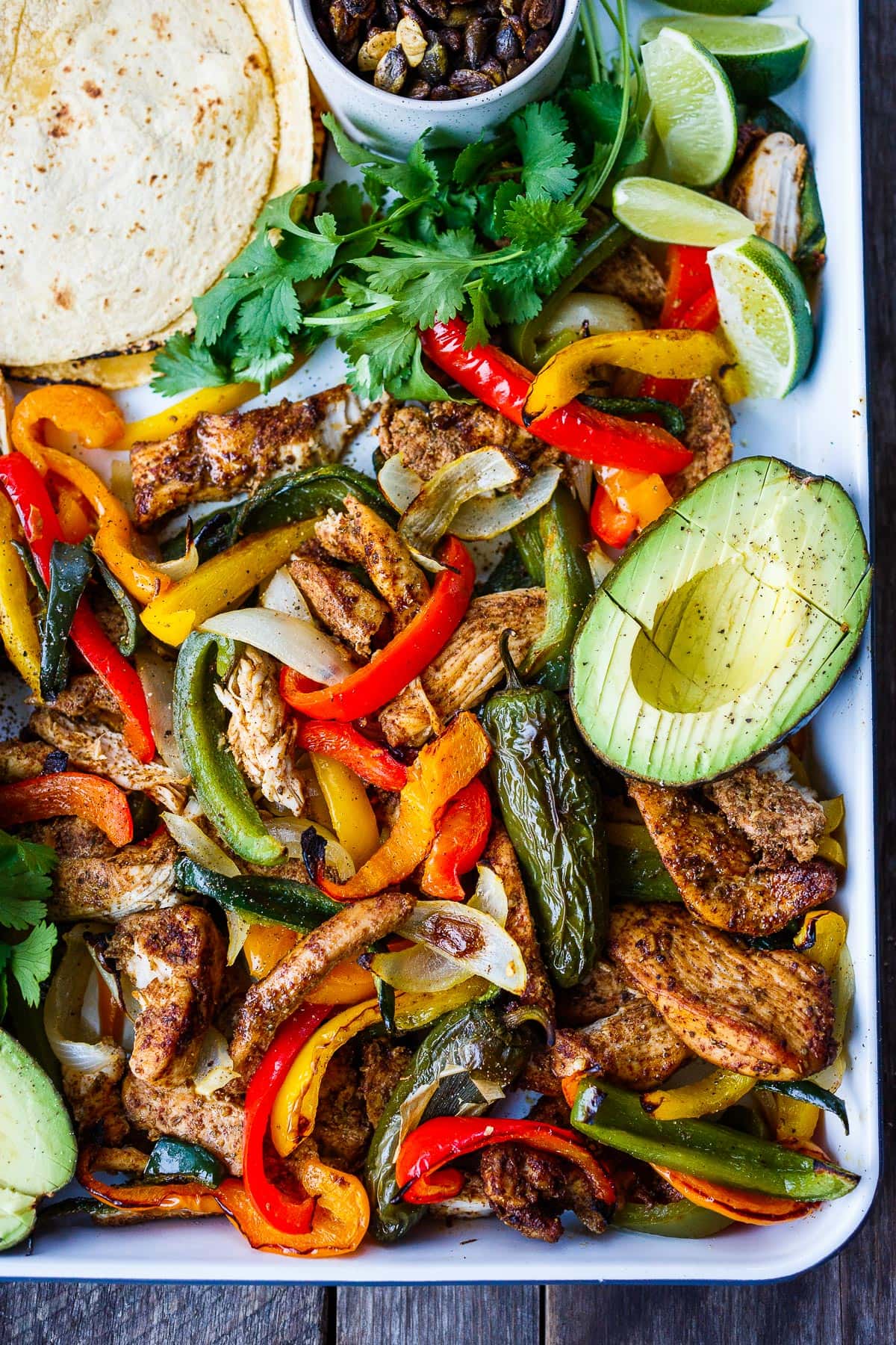 Sheet Pan Chicken Fajitas are a quick easy one-pan dinner! Deliciously marinated chicken and veggies are roasted until tender & succulent.