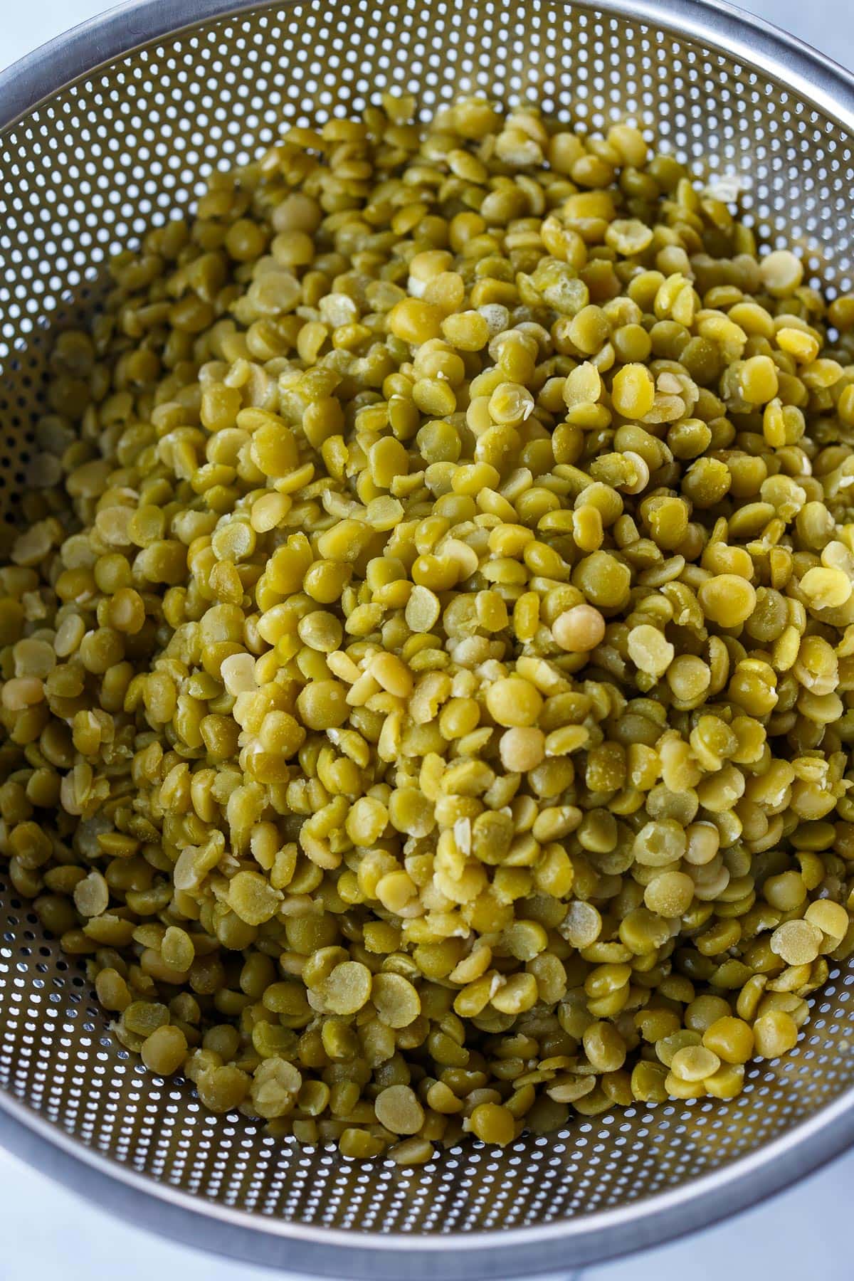 Cooked split peas in a colander. 
