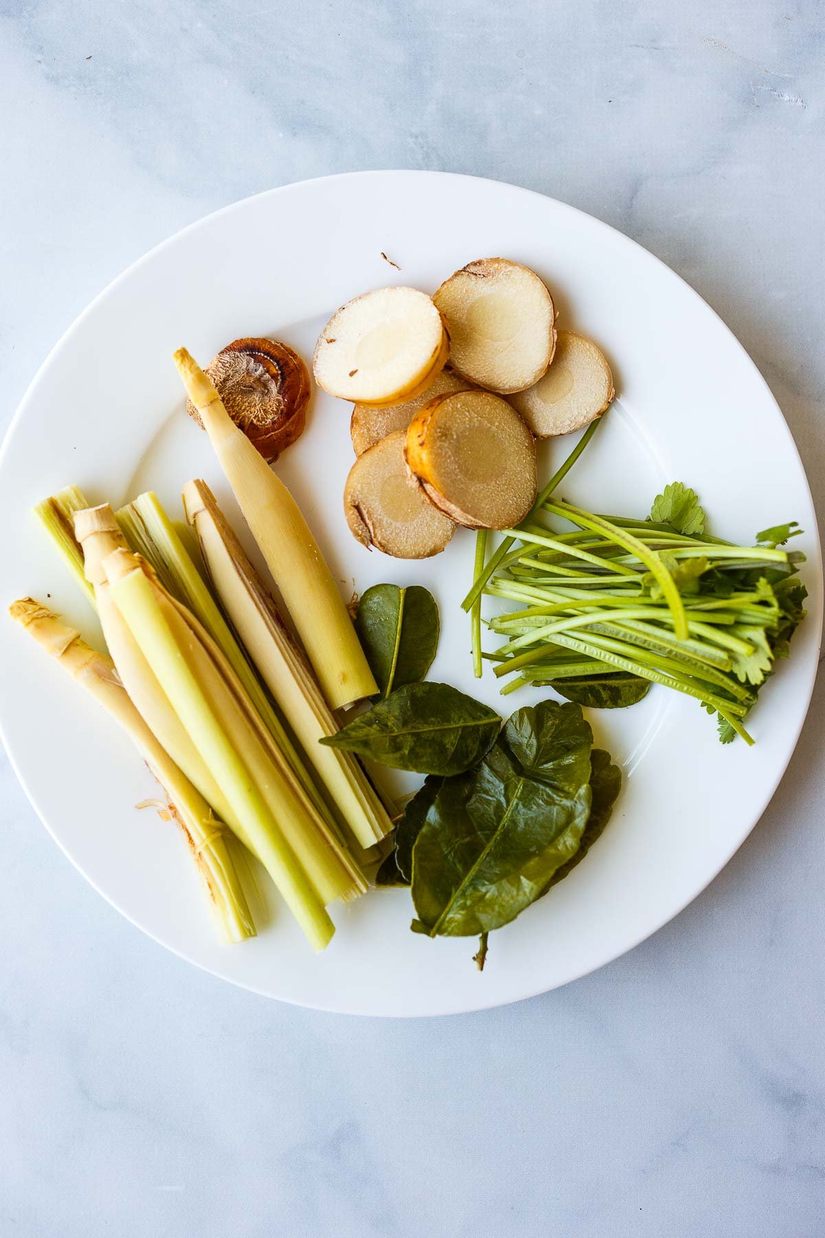 tom yum soup broth ingredients: galanga, kaffir lime leaves, lemon grass stalks.