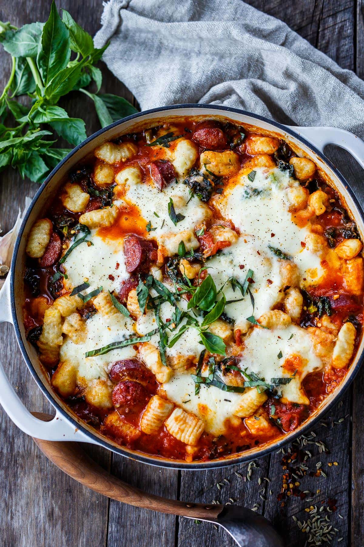 Baked gnocchi with tomato sauce, kale, Italian sausage, and melty mozzarella cheese - a delicious one-pot meal that can be made in 30 minutes. 