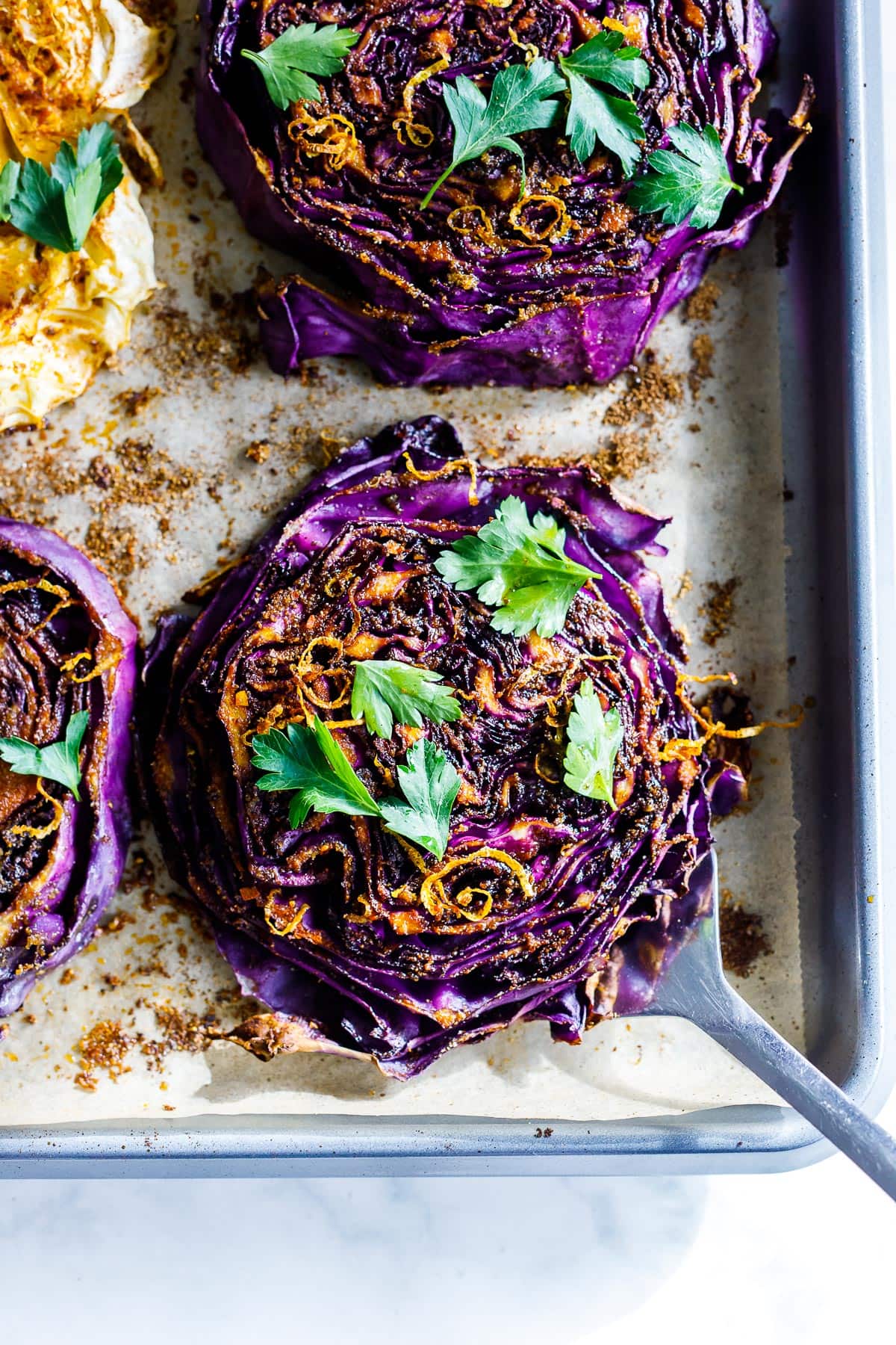 Tender, smoky Cabbage Steaks on a sheet pan. 