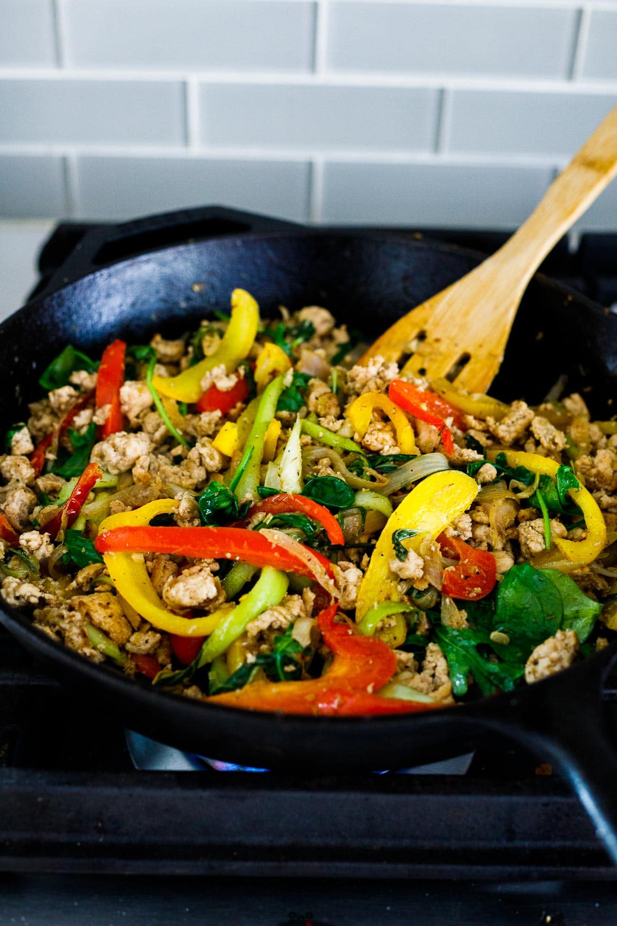 Stir frying the chicken with the veggies and sauce. 