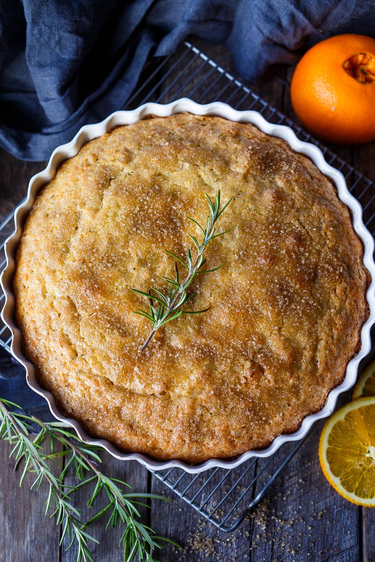 Enhanced with fresh rosemary and orange zest this Olive Oil Cake is easy to make, has a lovely  rustic texture and stays moist for days. Lightly sweetened, it is perfect for dessert, brunch or with afternoon tea.