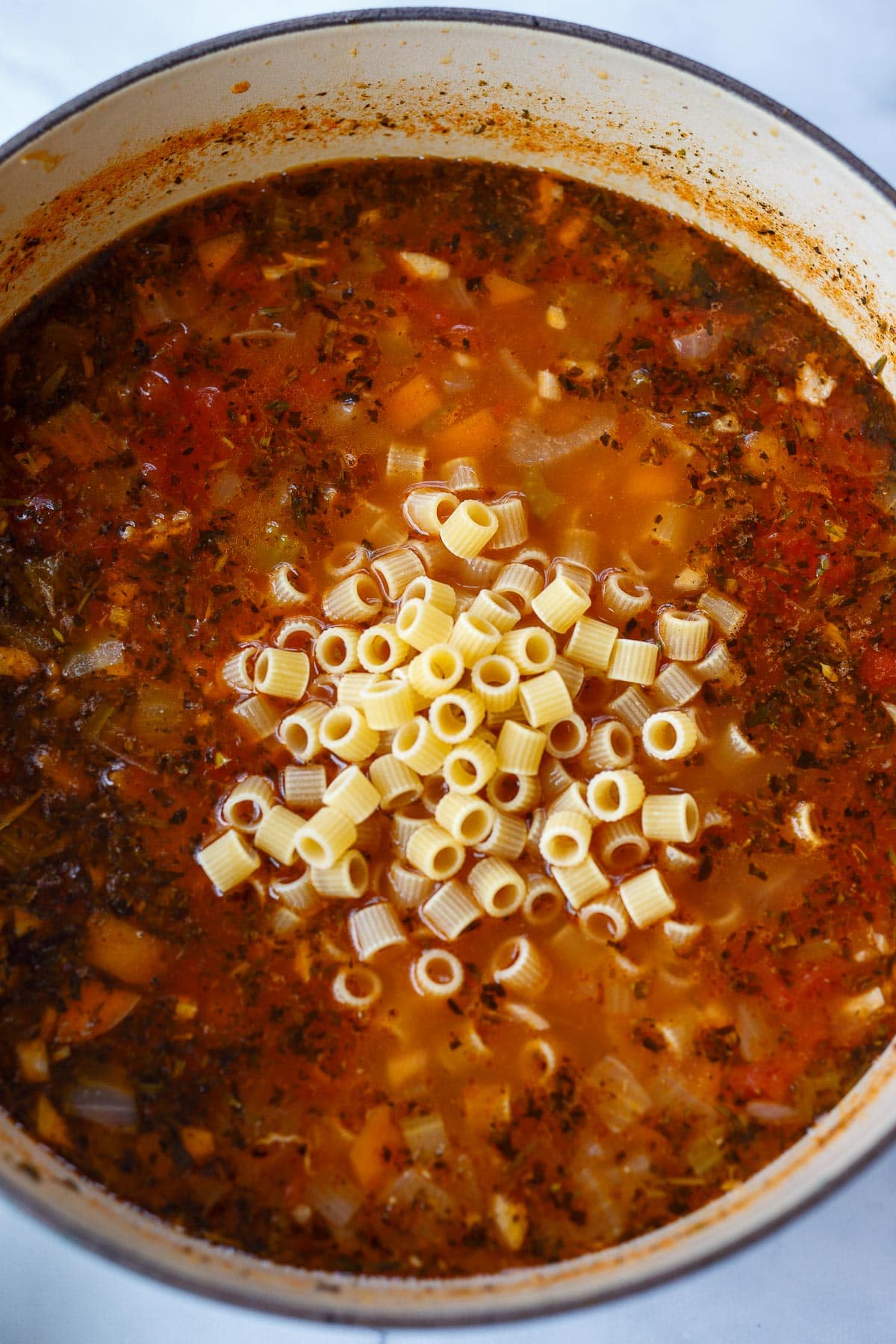 Dry pasta added to simmering soup.