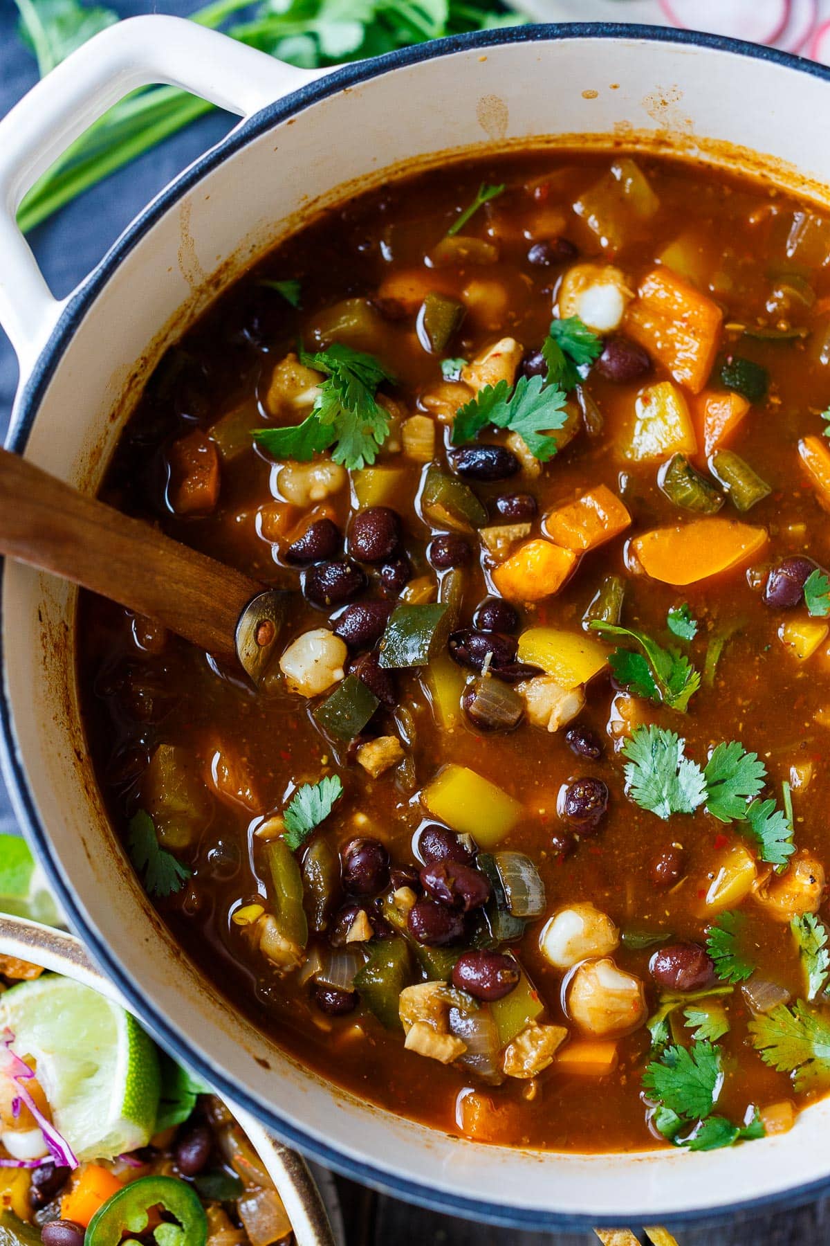 Vegan Pozole in a pot with lots of veggies, black beans, cilantro and hominy. 