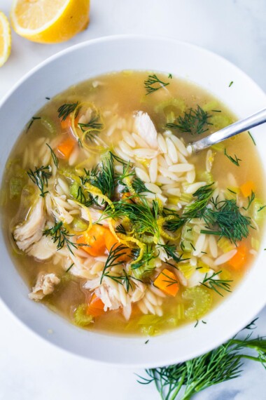 Lemon Chicken Orzo Soup with coriander and dill in a bowl