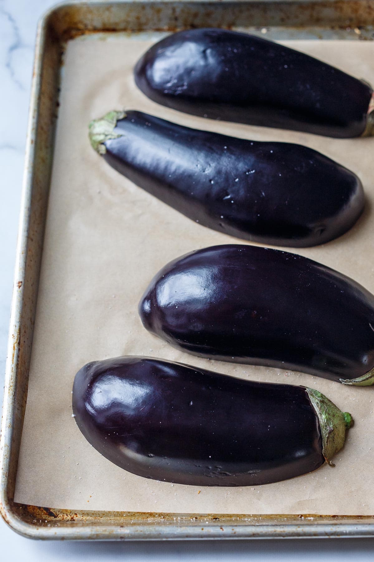 Eggplant halves on a baking sheet.