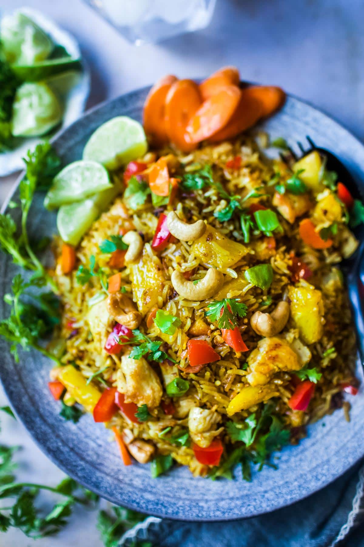 This Pineapple Fried Rice holds all the Thai flavors of spicy, sweet, and salty with a perfect tang from the pineapple and tops off with a crunchy nutty taste of cashew. It is a delicious Thai dish that is fast to put together. Vegan adaptable! #thaipineapplefriedrice #pineapplefriedrice