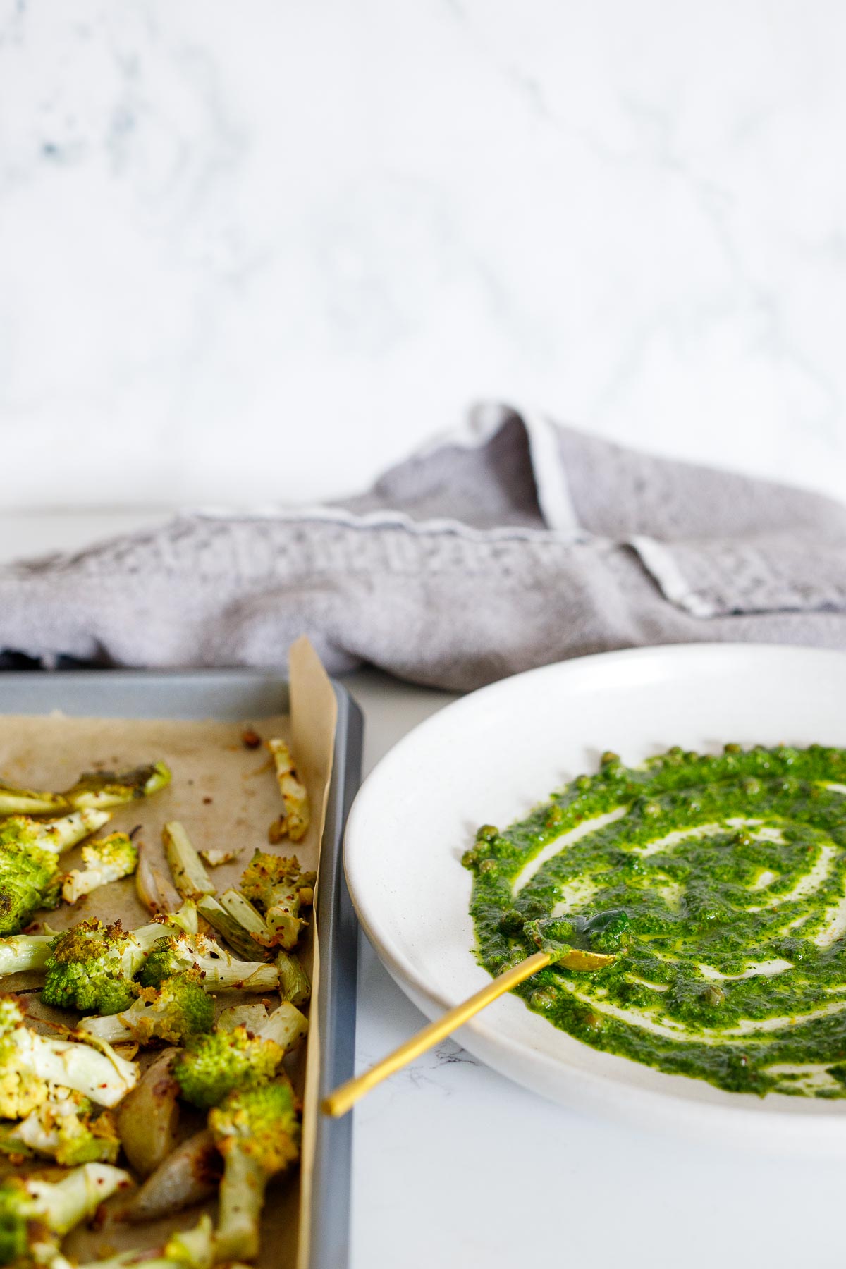 Plating roasted romanesco over a sauce of salsa verde on a white plate