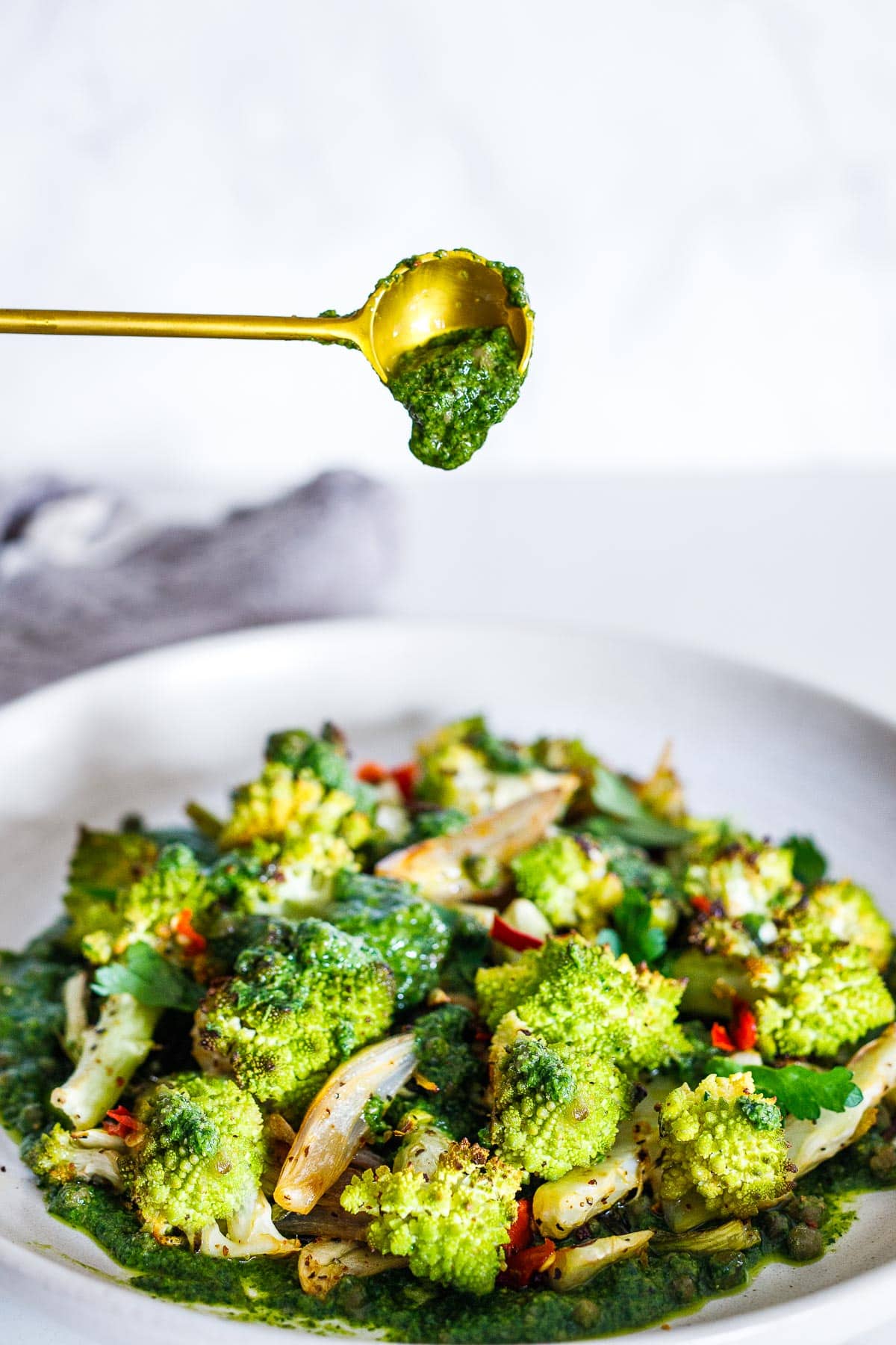 Spooning salsa verde over the Romanesco. 