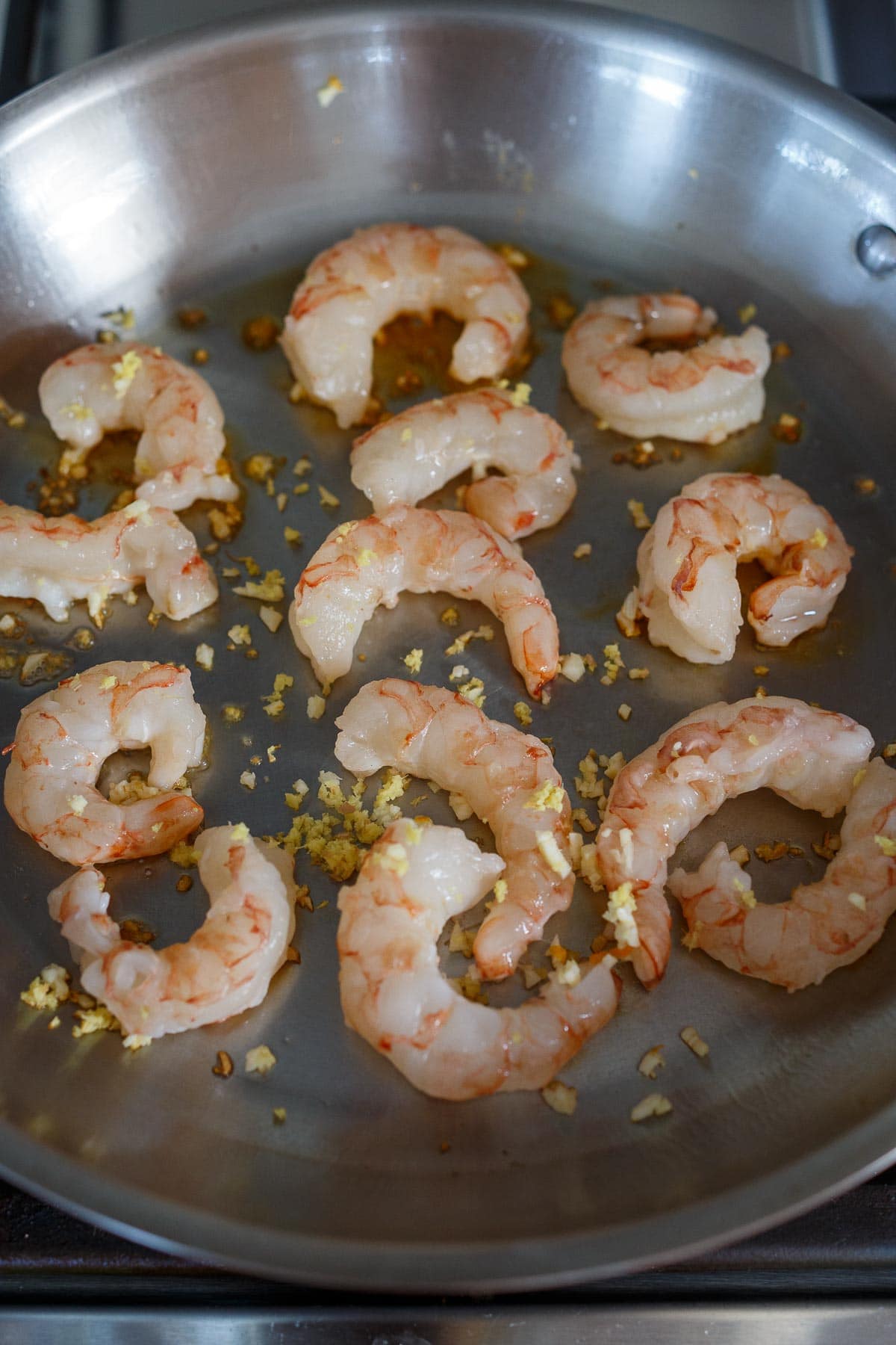 Shrimp in sauté pan with ginger and garlic.