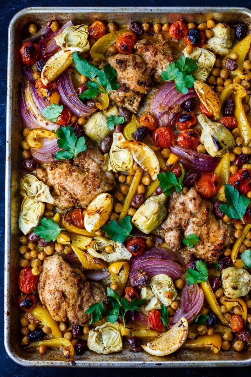 Mediterranean Chicken with veggies, chickpeas, olives and herbs. A delicious sheet pan dinner that is easy to make and easy to clean up! 