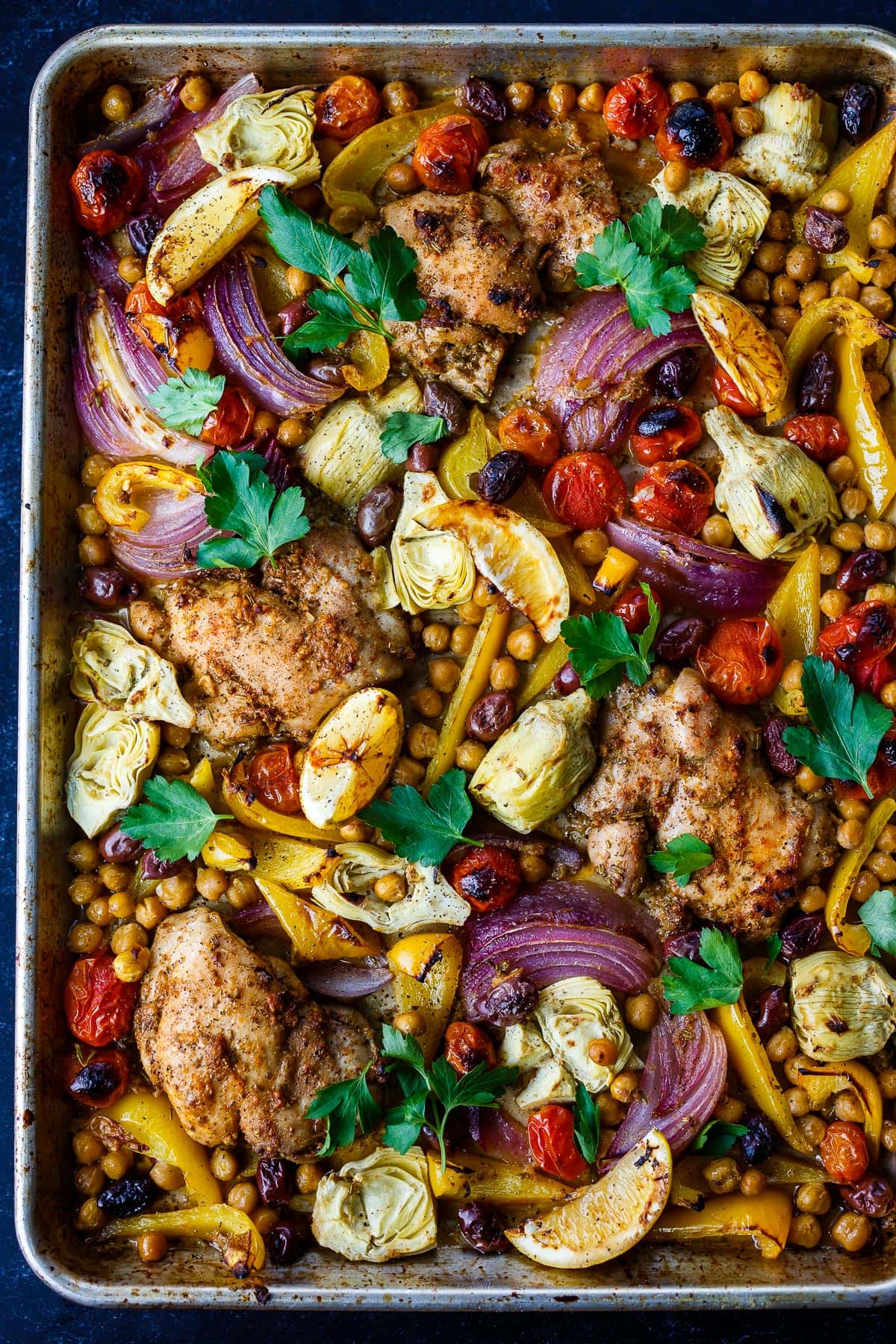 Mediterranean Chicken with veggies, chickpeas, olives  and herbs. A delicious Sheet Pan Dinner. 