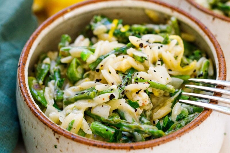 This recipe for Asparagus Orzo is perfect for spring! Quick and easy, this vegetarian dinner can be made in 30-minutes! Enjoy it as a side dish or see notes on how to serve it chilled as a salad.