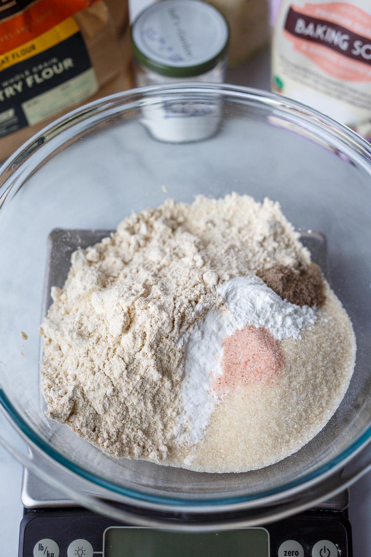 Dry ingredients of muffins in a glass bowl on the scale.