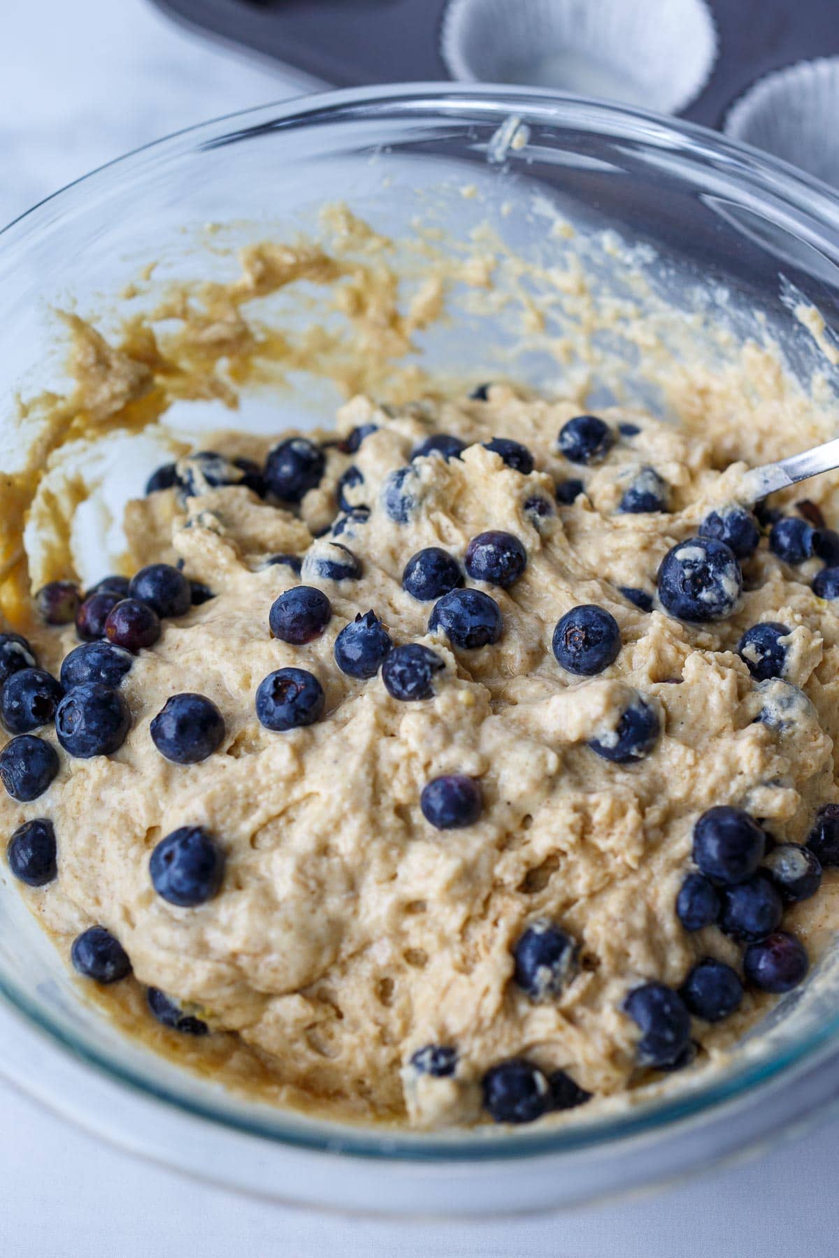 Stirring blueberries into the batter.