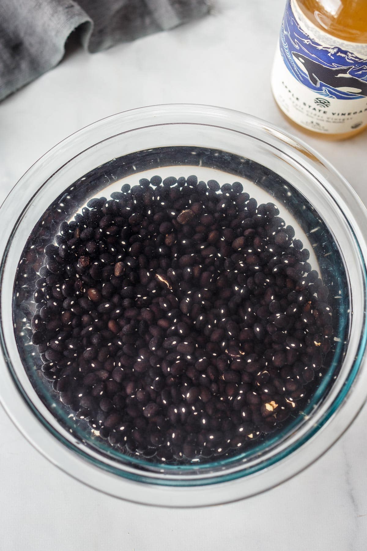 Black beans soaking in a bowl.