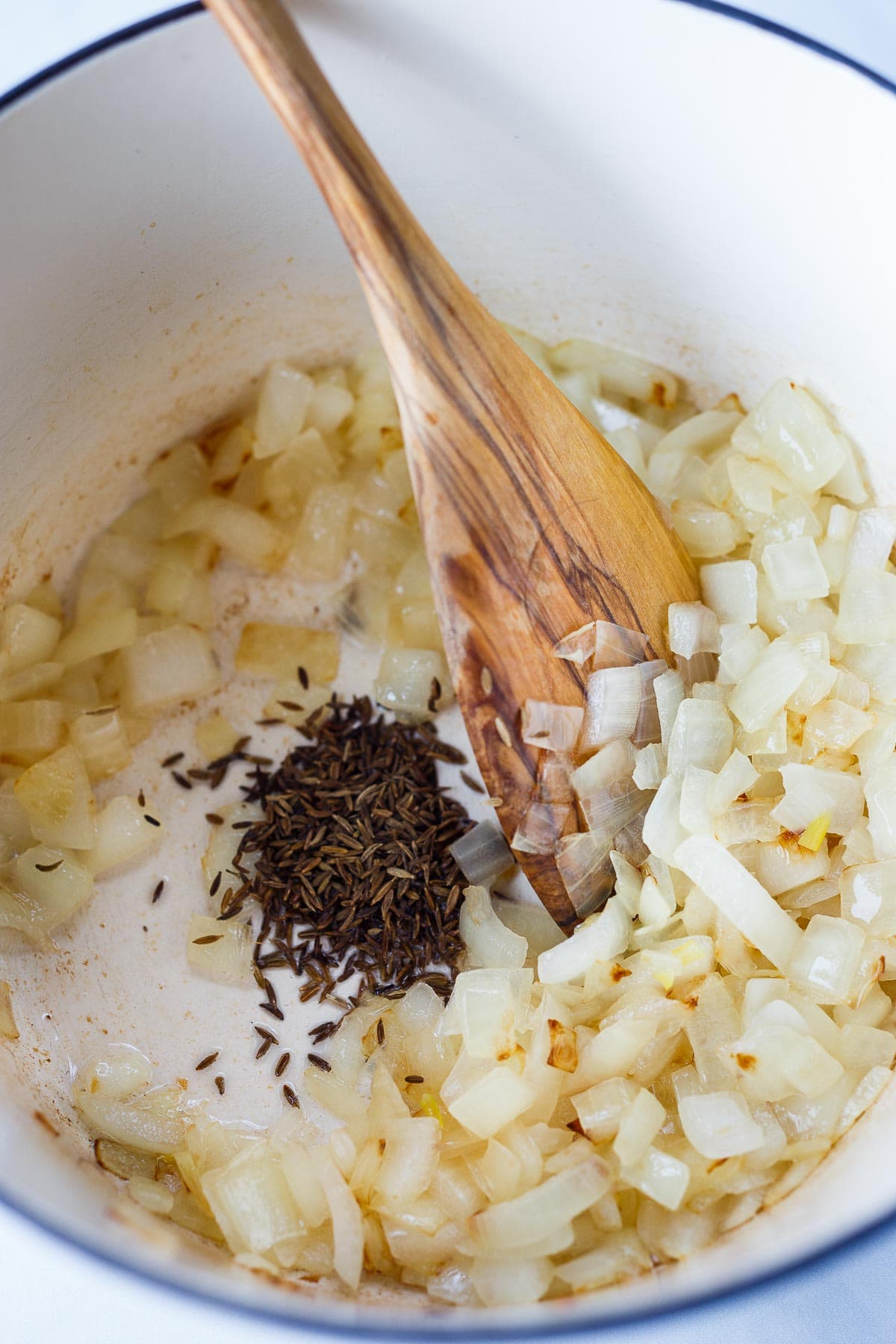 Onions and cumin sautéing in a pan.