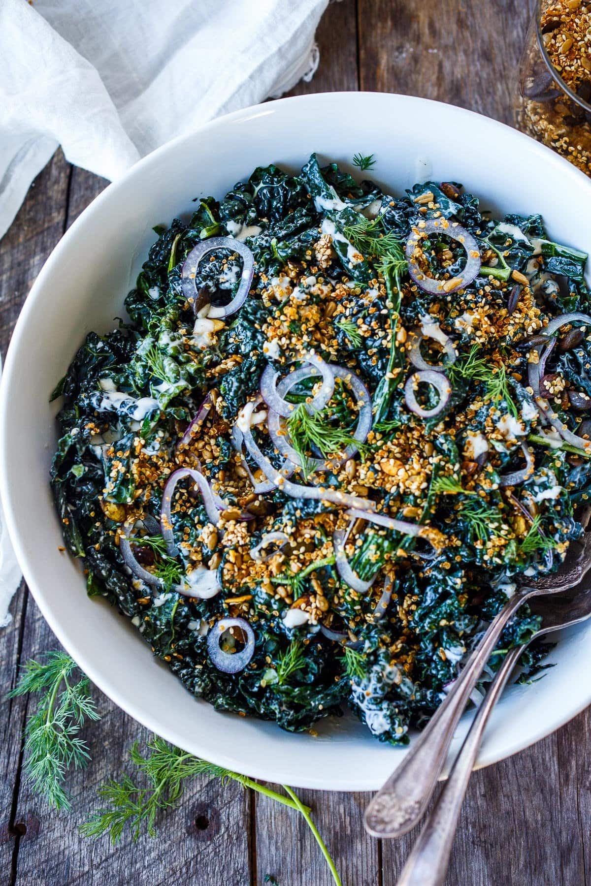 Full of healthy texture and flavor, this nutrient-dense Kale Salad is enhanced with creamy buttermilk dressing, tamed red onions and topped with an addicting crunchy quinoa salad topper.