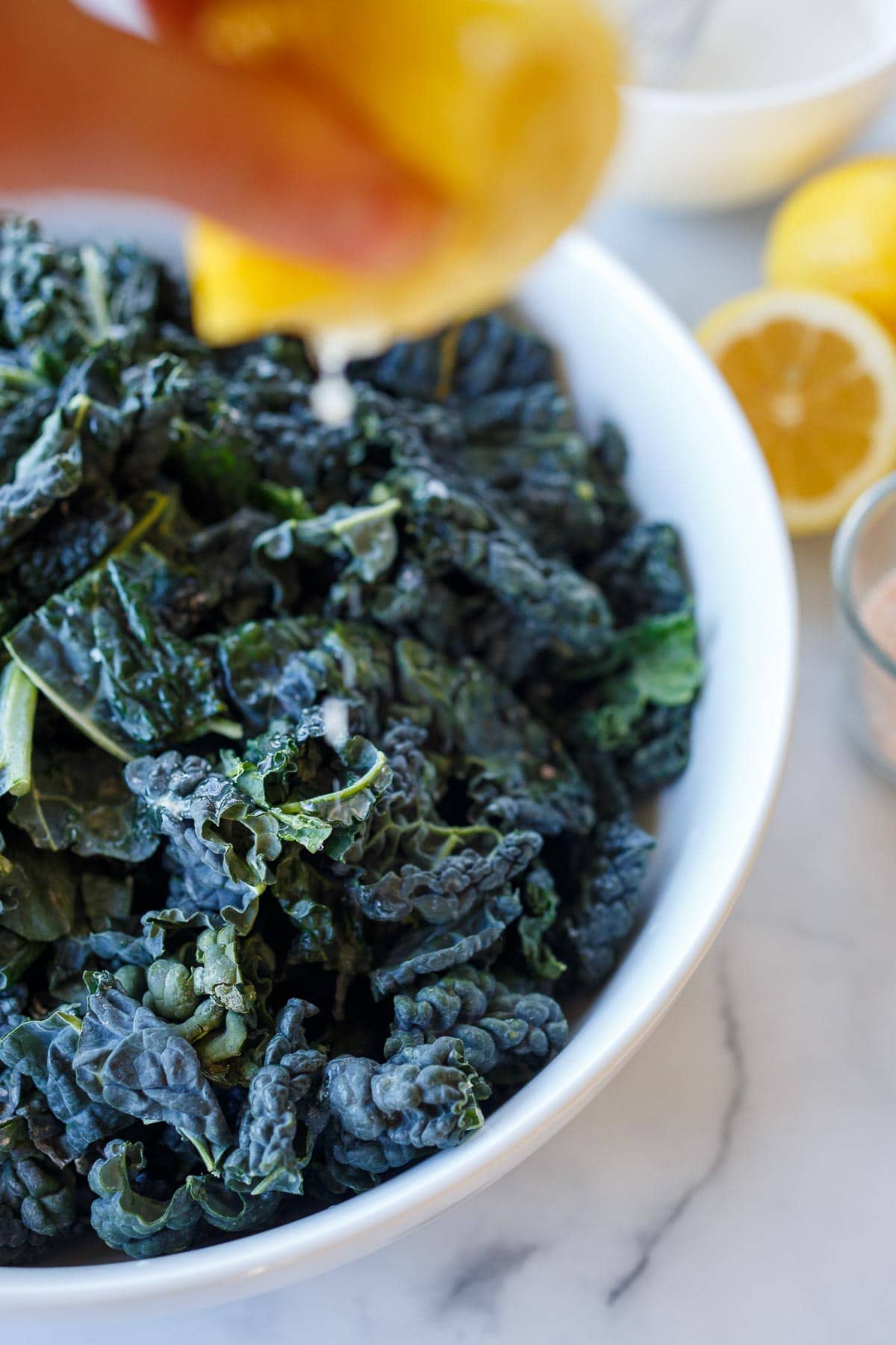 Squeezing lemon onto kale leaves.