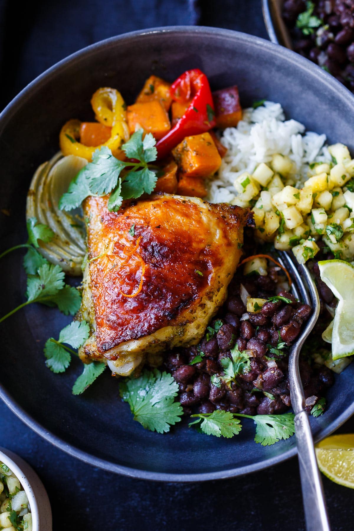 A delicious recipe for Cuban Mojo Chicken. Thighs and legs roasted in the oven with a citrusy mojo marinade alongside yams and peppers. An easy sheet pan dinner!  