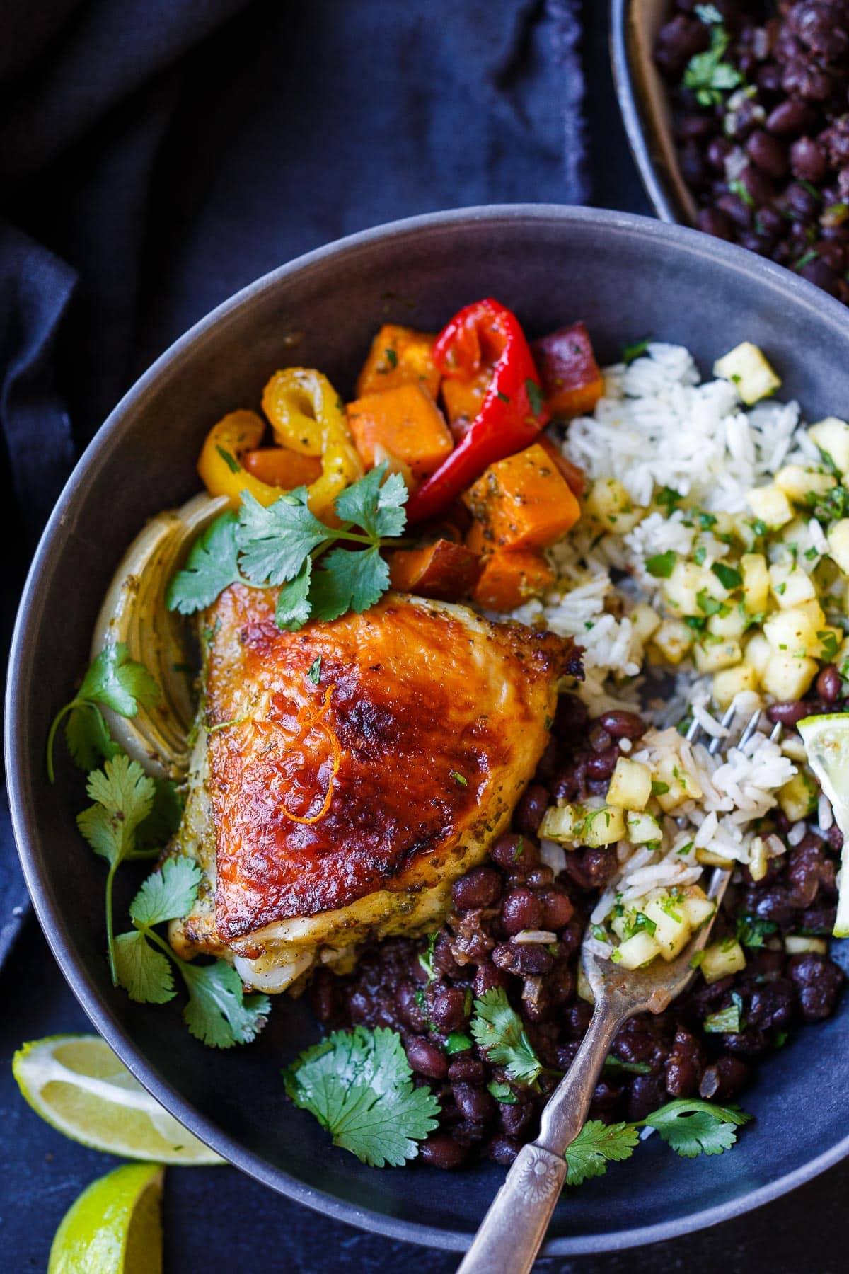 A delicious recipe for Cuban Mojo Chicken. Thighs and legs roasted in the oven with a citrusy mojo marinade alongside yams and peppers. An easy sheet pan dinner!  