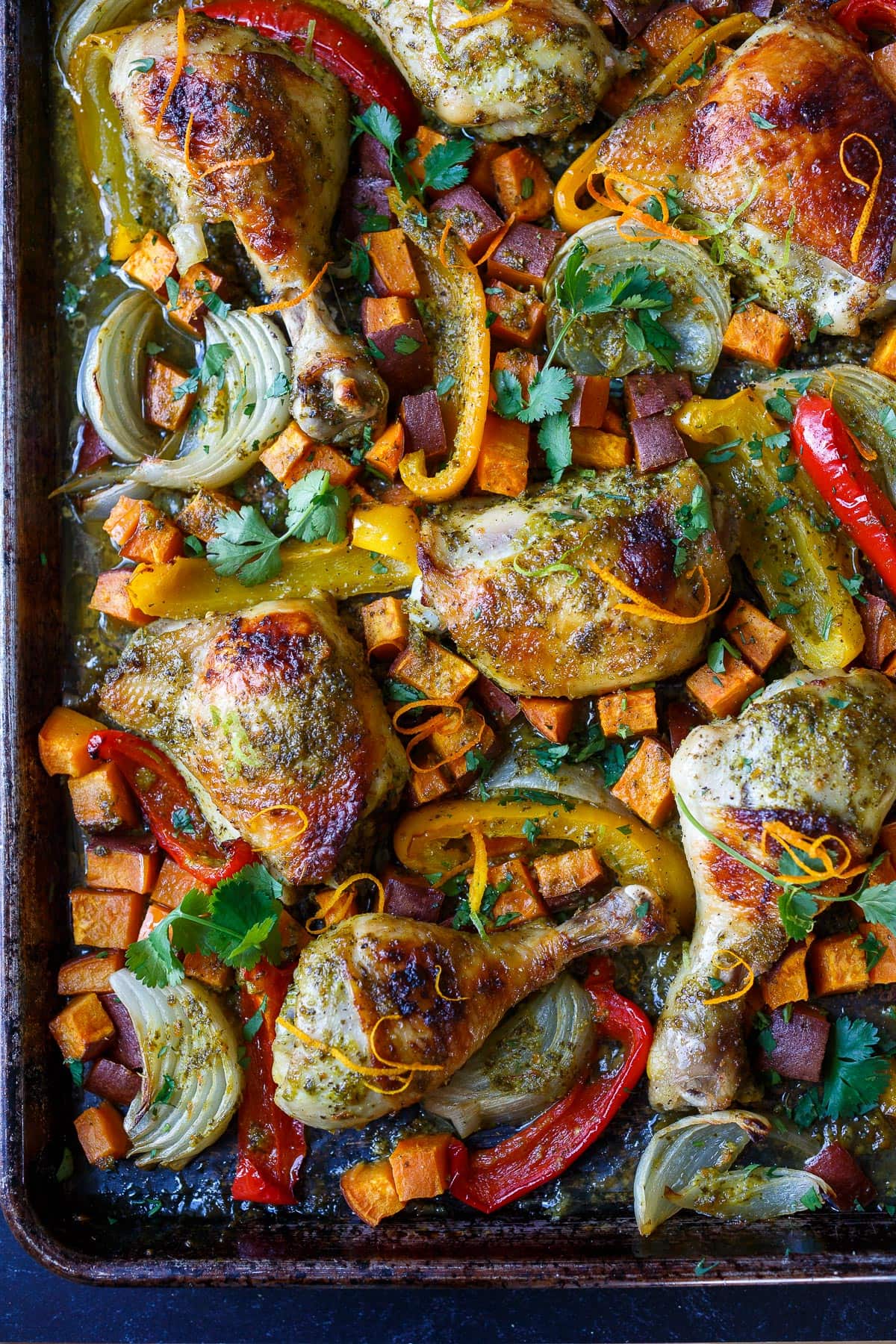 A delicious recipe for Cuban Mojo Chicken. Thighs and legs roasted in the oven with a citrusy mojo marinade alongside yams and peppers. An easy sheet pan dinner!