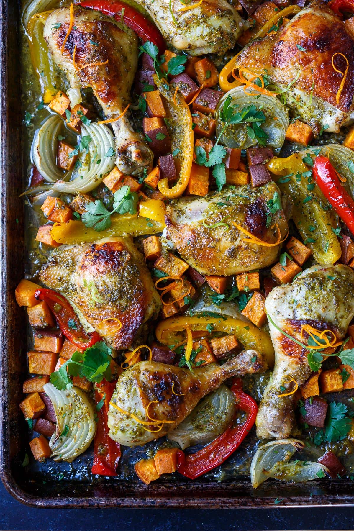 A delicious recipe for Cuban Mojo Chicken. Thighs and legs roasted in the oven with a citrusy mojo marinade alongside yams and peppers. An easy sheet pan dinner!  