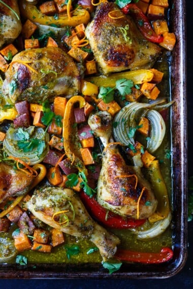 A delicious recipe for Cuban Mojo Chicken. Thighs and legs roasted in the oven with a citrusy mojo marinade alongside yams and peppers. An easy sheet pan dinner!