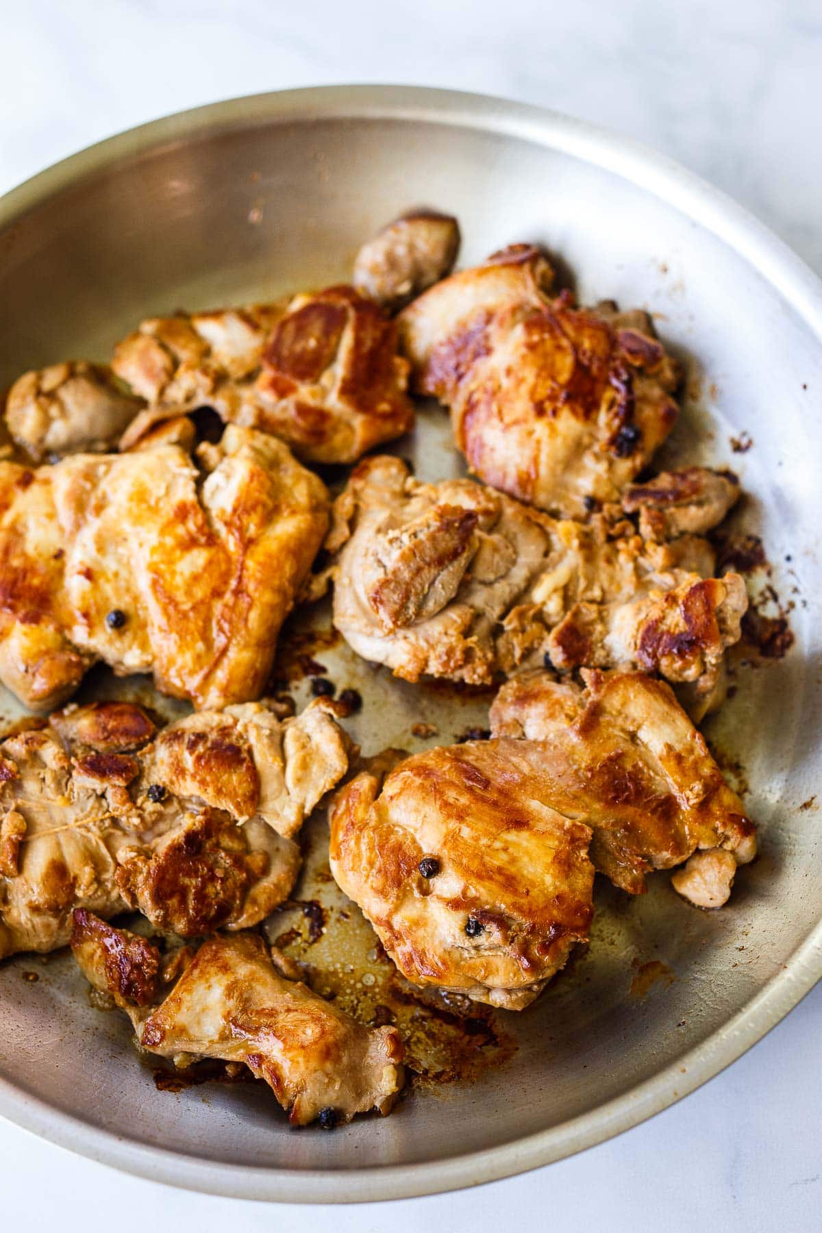 Seared chicken in a pan.