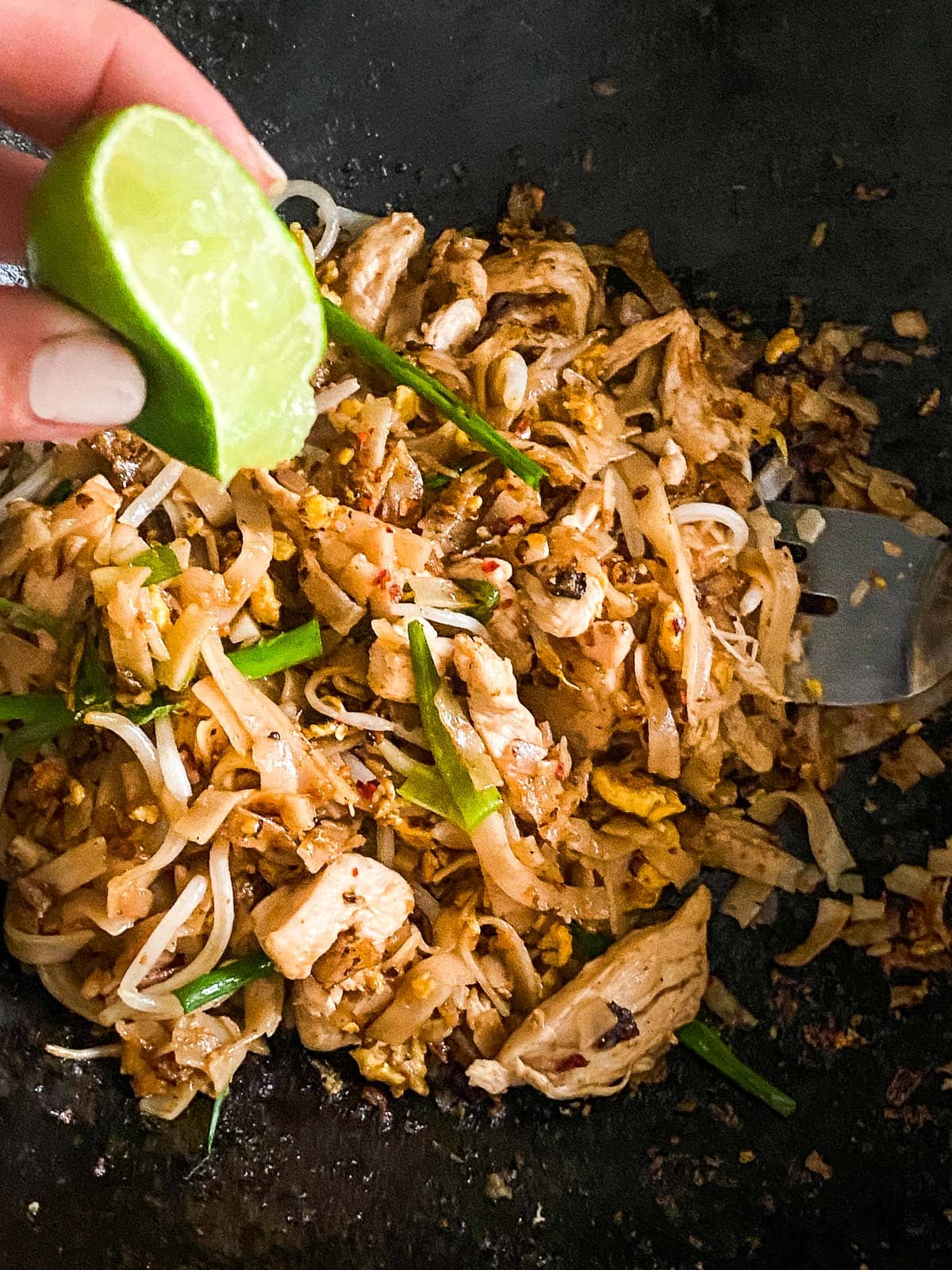 squeezing the pad thai with lime