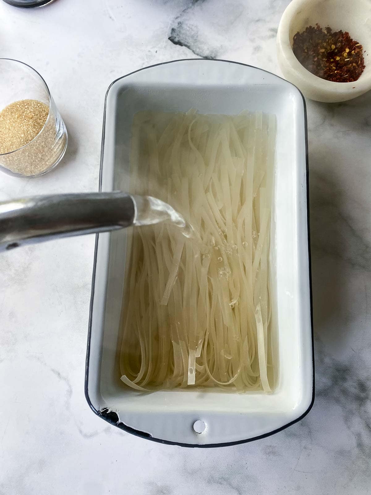 Soaking the rice noodles with boiling water.