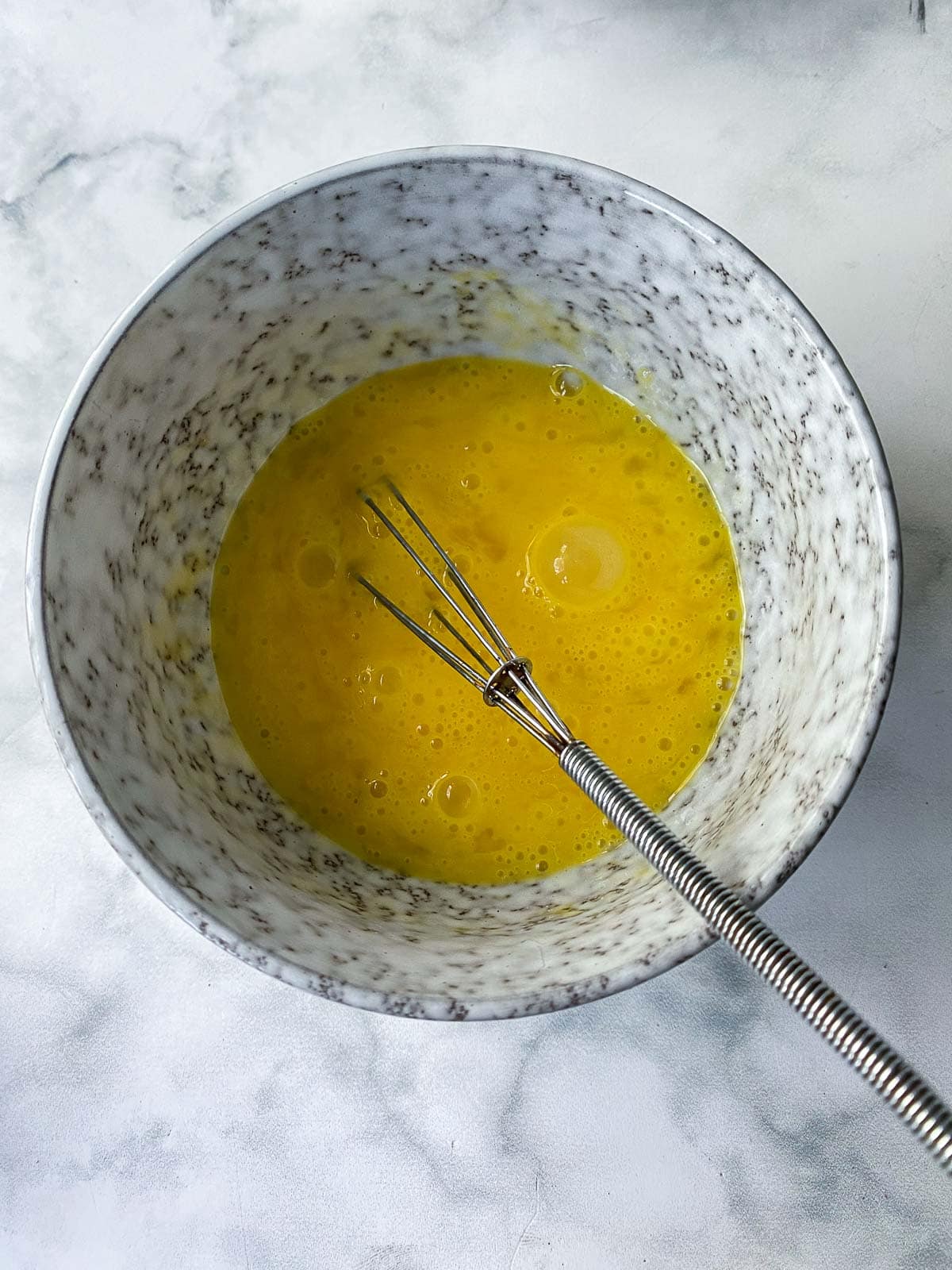 Whiskng the eggs in a bowl. 