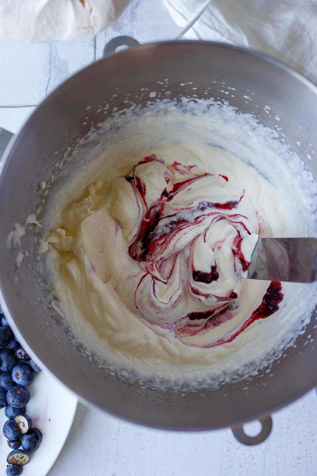 Folding in jam into whip cream.