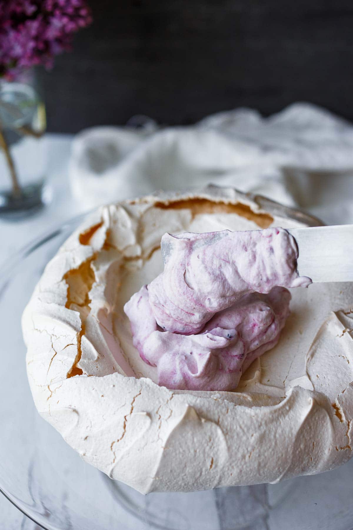 Putting whip cream onto the pavlova.