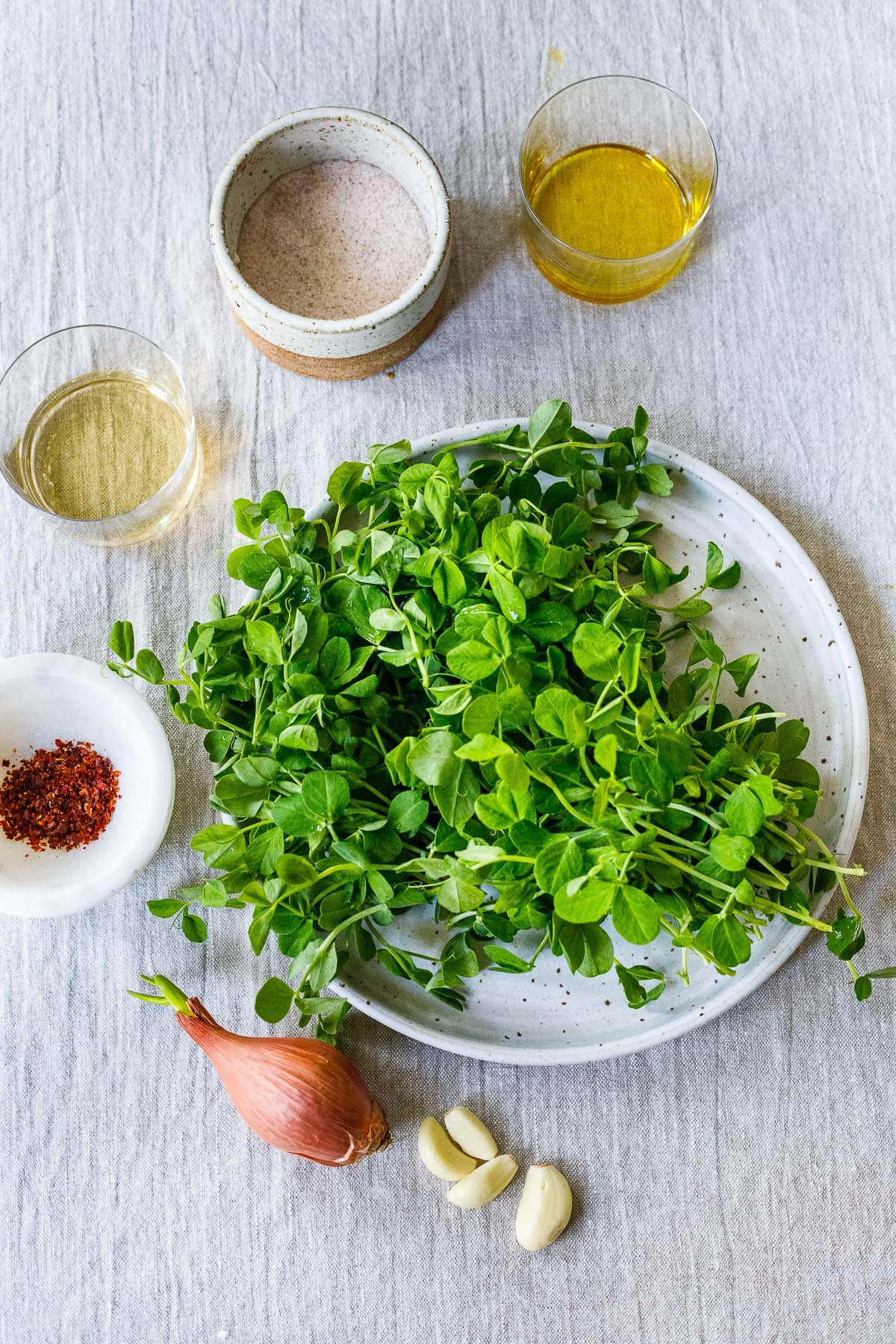 Ingredients in Pea Shoots recipe on a table. 