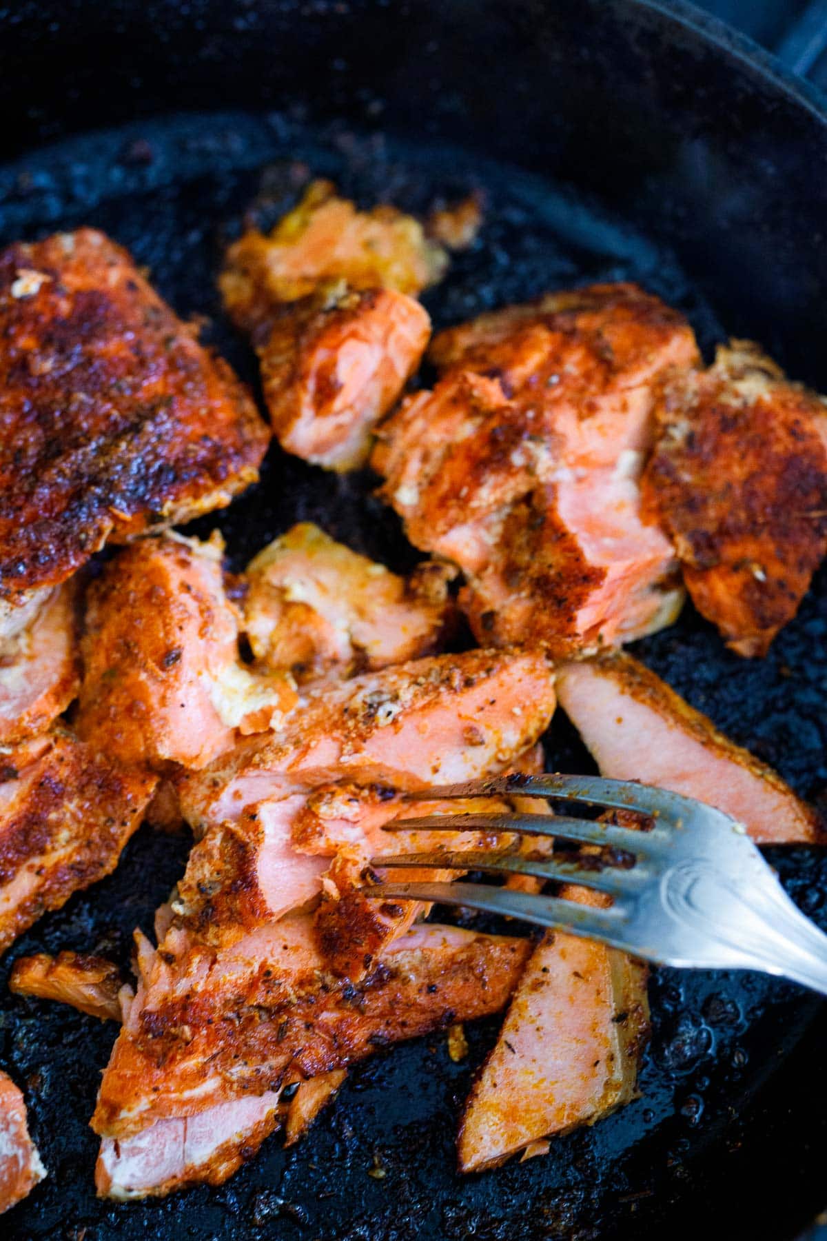 flaking salmon apart with a fork.