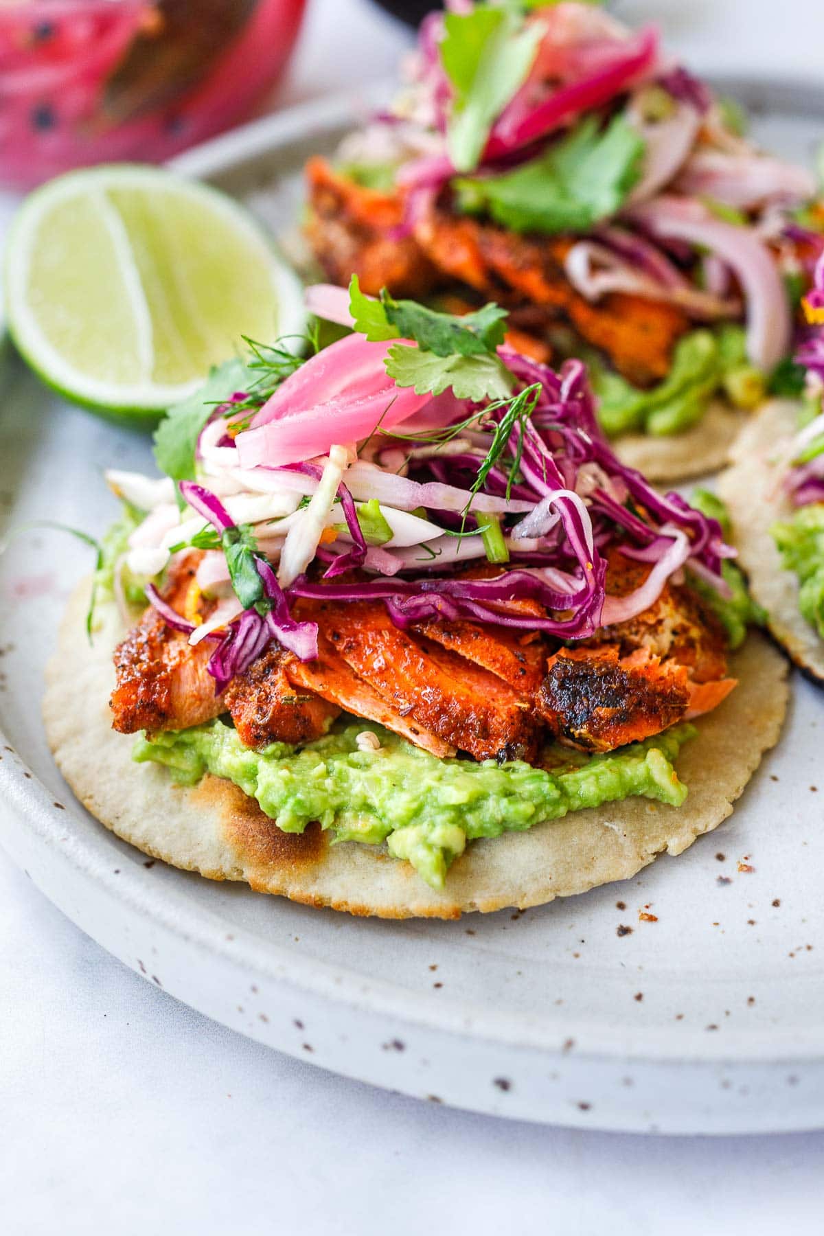 Salmon Tacos with cajun spice,  cabbage slaw, avocado, pickled onions and taco sauce. 