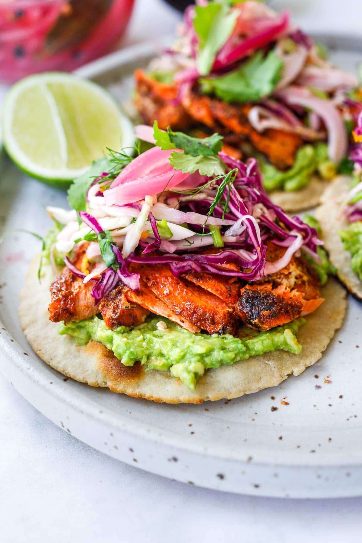 Salmon Tacos with cajun spice, cabbage slaw, avocado, pickled onions and taco sauce.