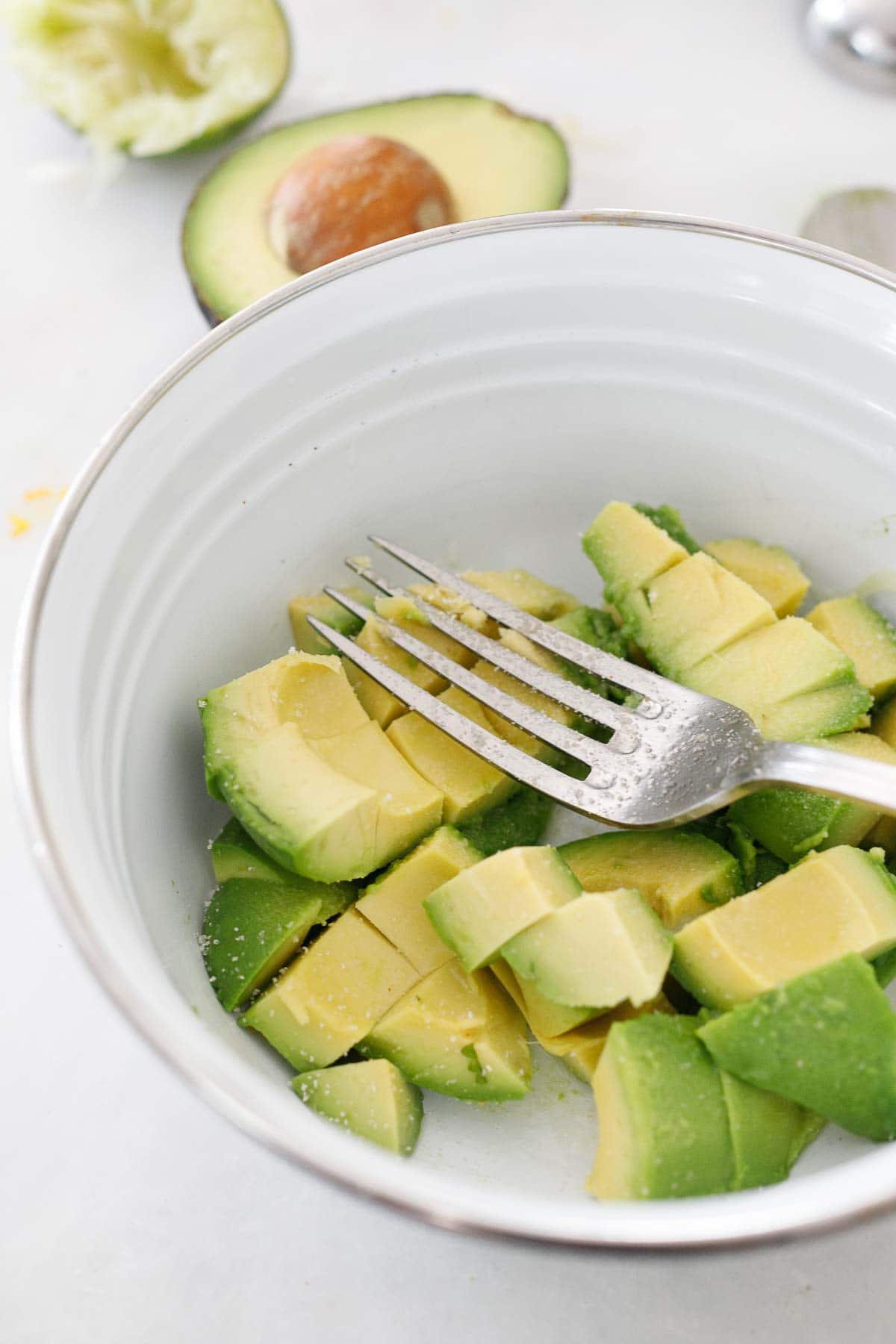 Mashing avocado in a bowl.