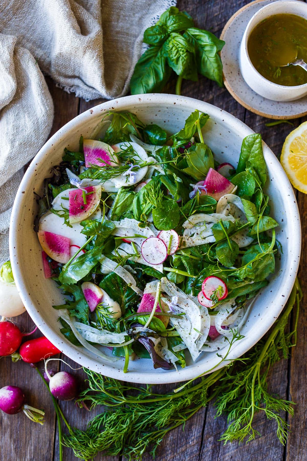 Spring Salad made with spring greens, fresh herbs, shaved fennel, and radishes tossed in a lemon dressing.