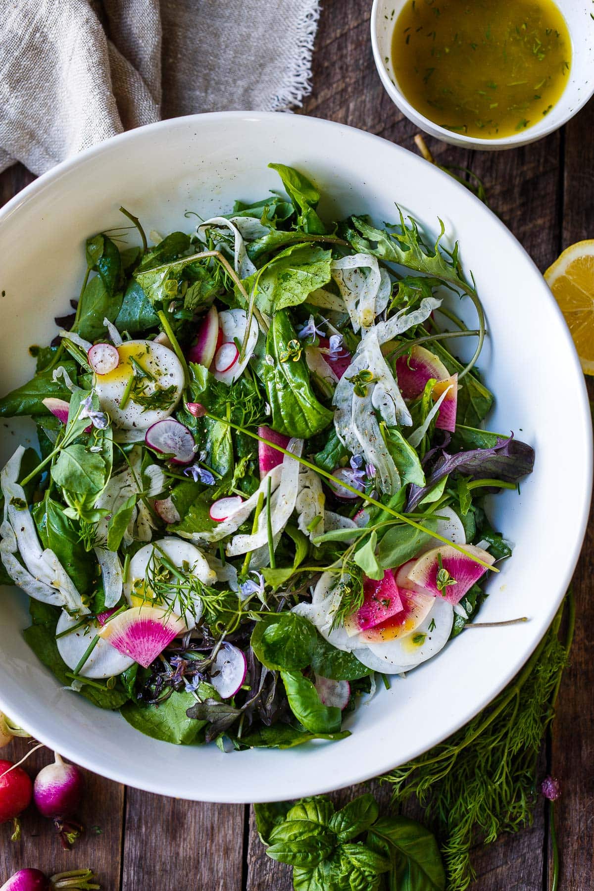 Simple, herby, and delicious, this spring salad recipe is made with tender spring greens, fresh herbs, shaved fennel, and radishes tossed in a lemon dressing